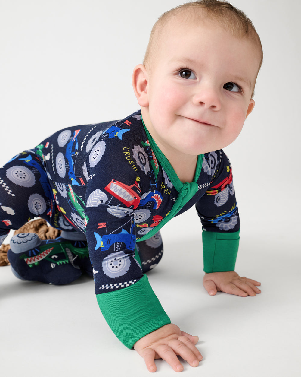 Crawling baby wearing the Monster Truck Madness Zippy