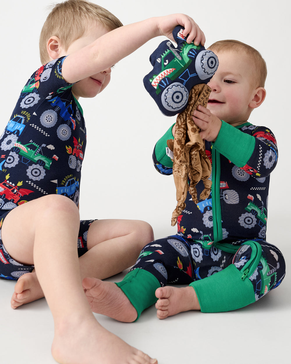 Two children playing with the Max the Monster Truck Sleepyhead Lovey