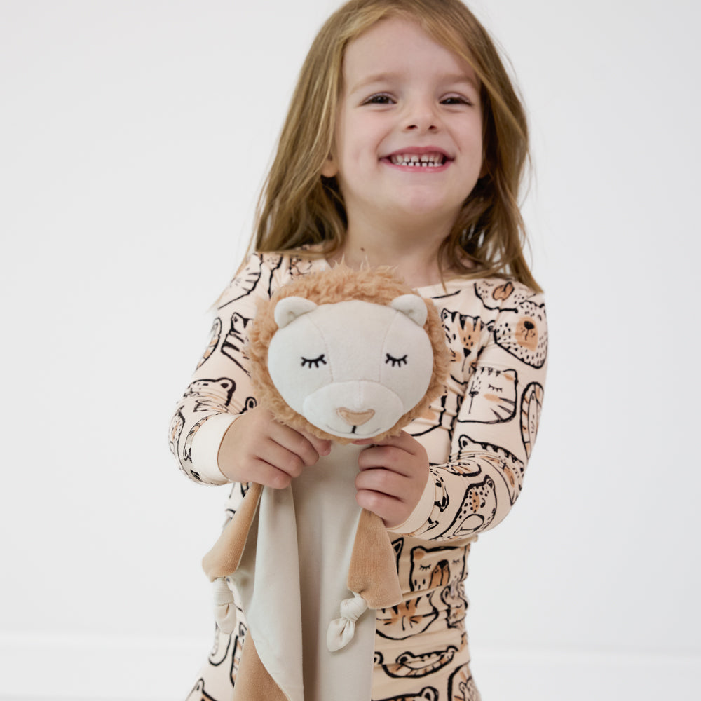 Image of a child holding up a Lion Lovey