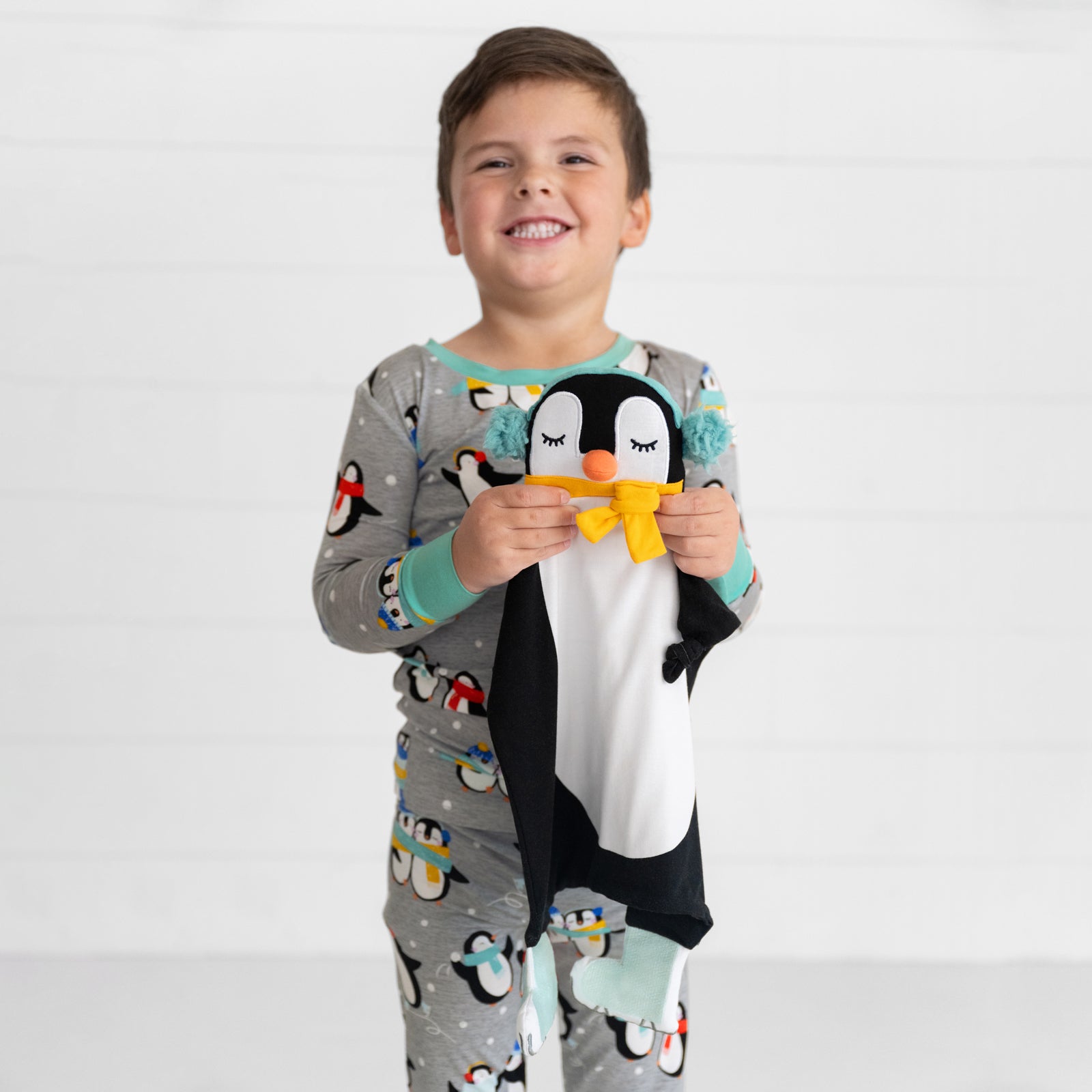 image of a child holding a Tux the penguin lovey