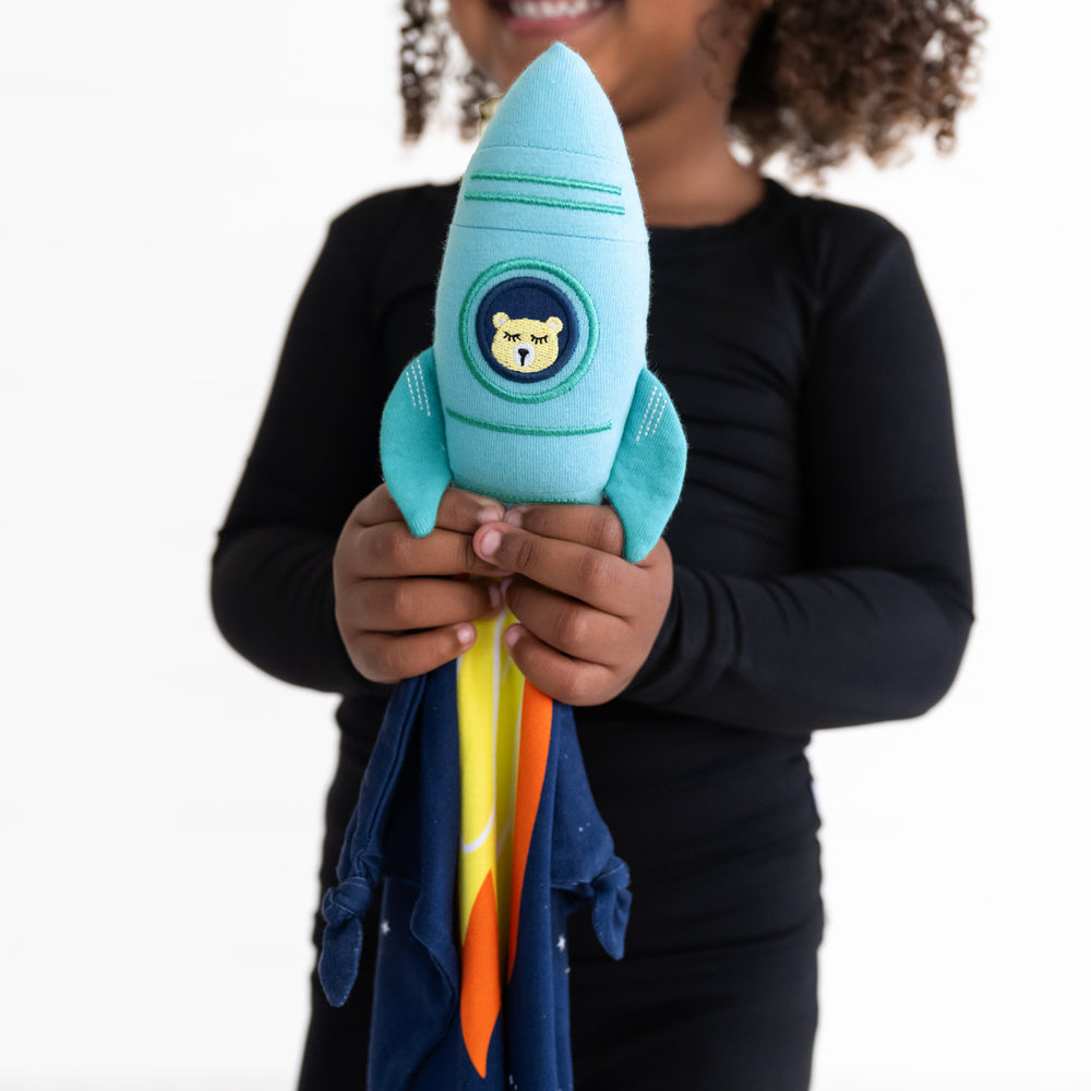 image of a child holding up an Astro sleepyhead lovey