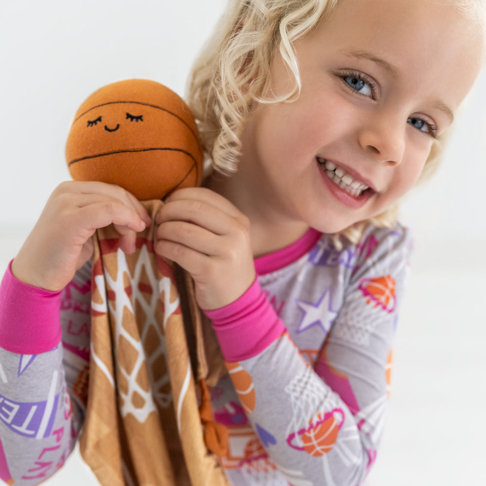 Child holding up Hoops the Basketball Sleepyhead Lovey