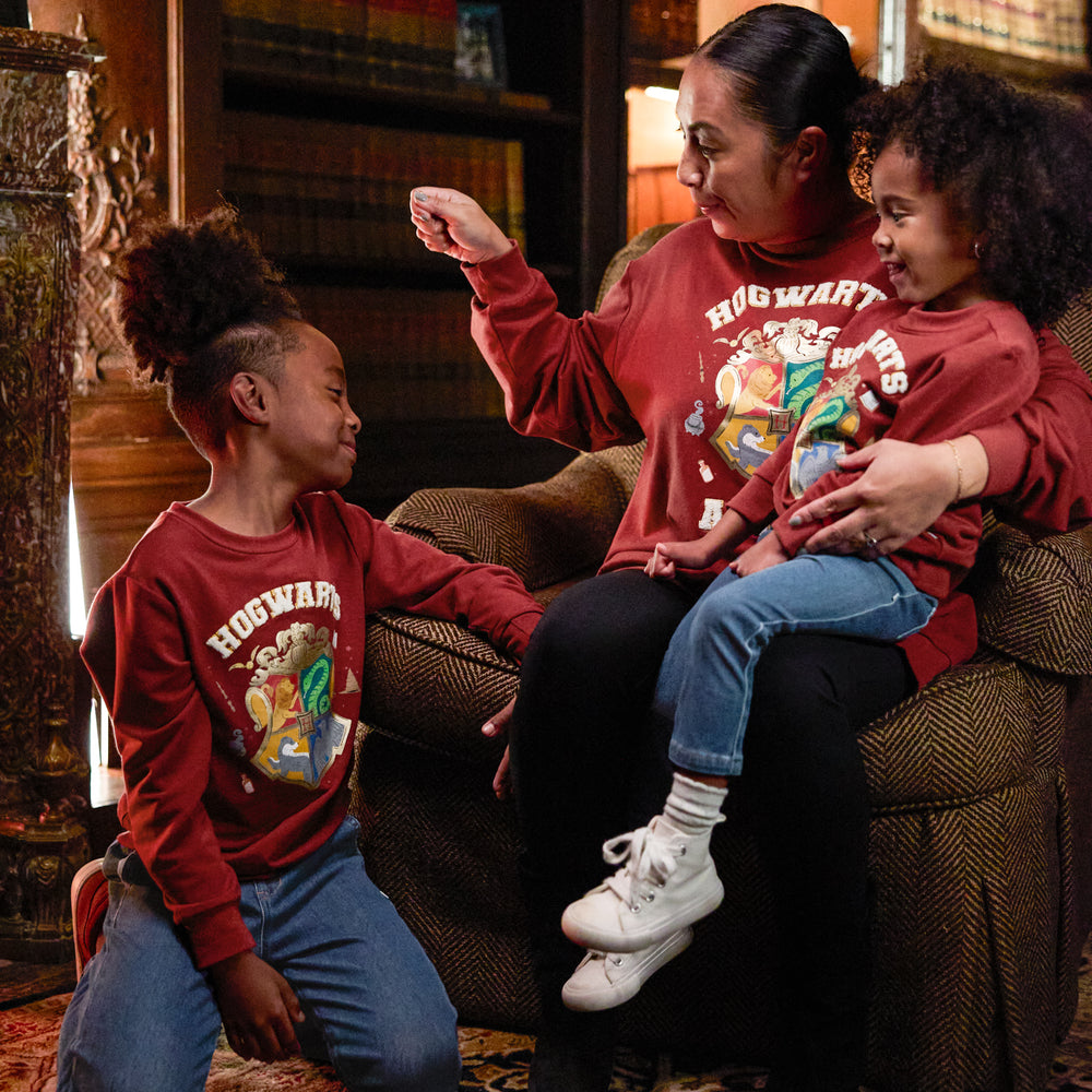 Mother and two children wearing matching Hogwarts Crewneck Sweatshirts