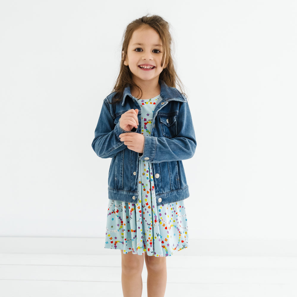 Child wearing a Friends Forever twirl dress with a midwash blue denim trucker jacket