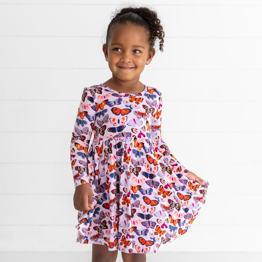 Girl posing while wearing the Butterfly Kisses Twirl Dress