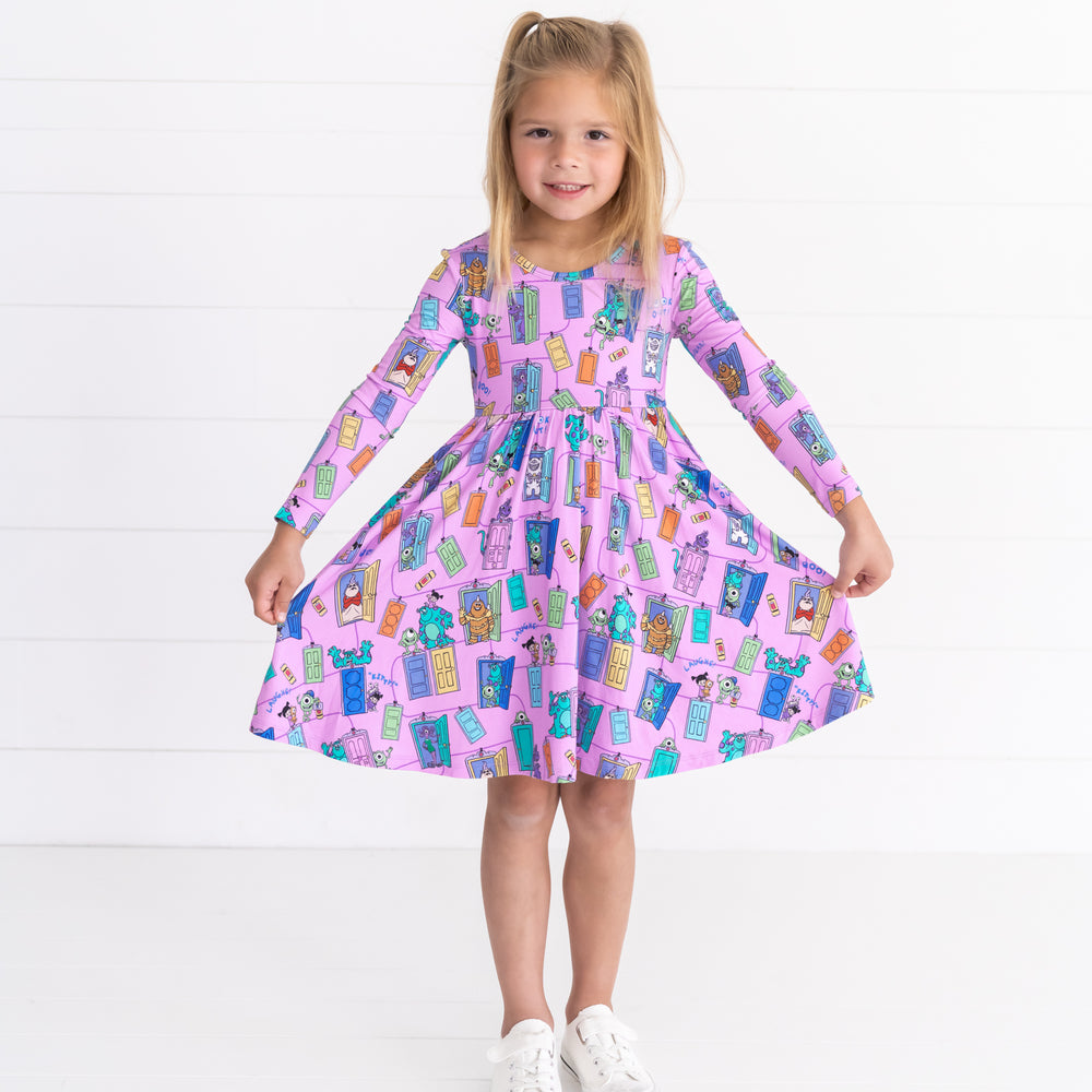 Smiling girl posing while wearing the Disney Monsters, Inc. Scream Team Twirl Dress