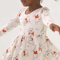 Close up image of a child wearing a Disney Winnie the Pooh twirl dress