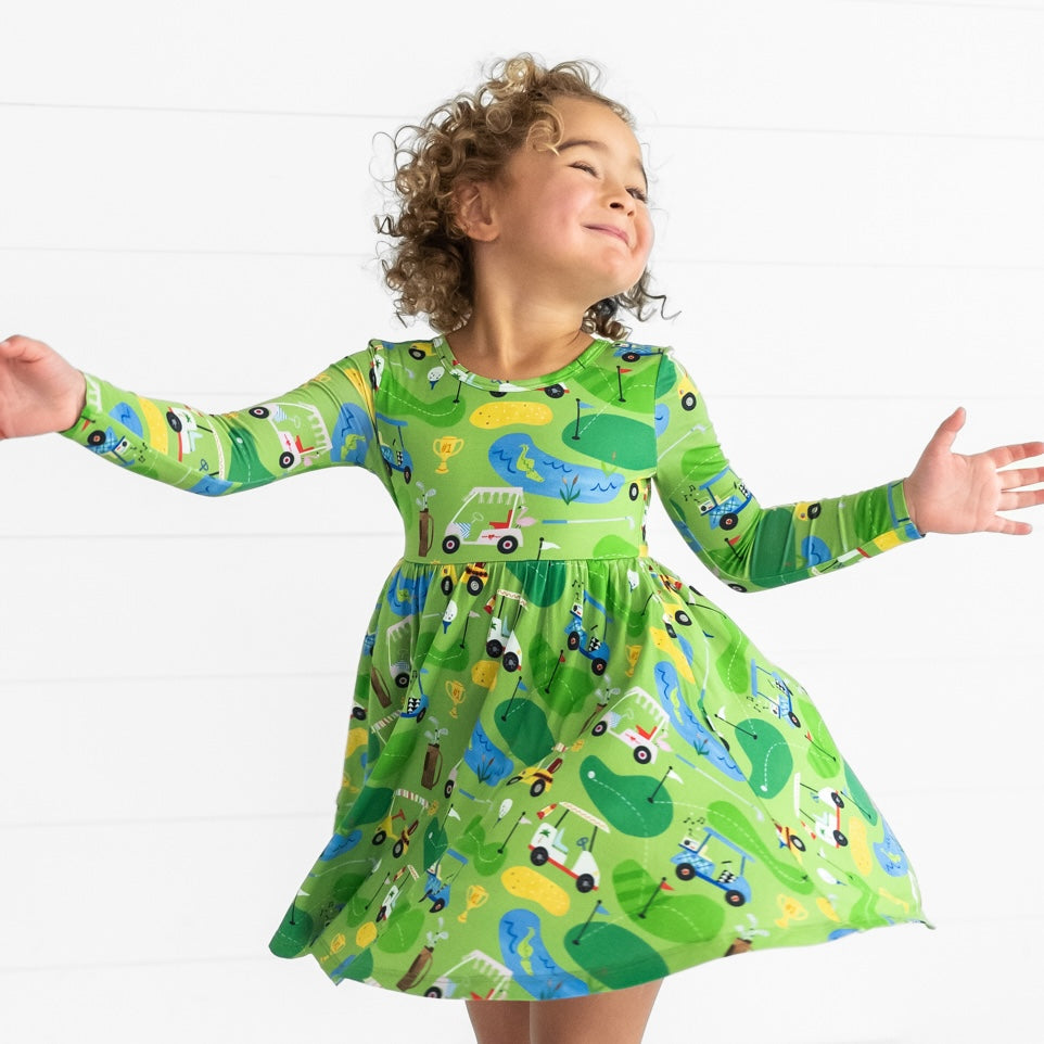 Image of a child spinning around wearing a Fairway Fun Twirl Dress