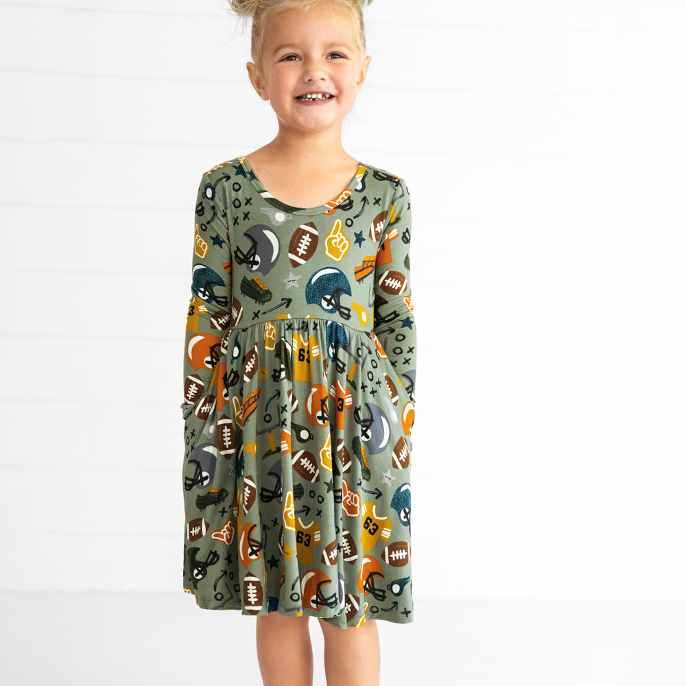 Image of a child wearing a Touchdown Time Twirl Dress