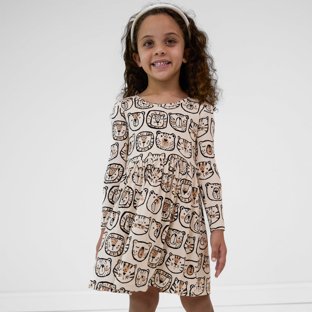 Child wearing a Lions, Tigers & Bears long sleeve skater dress featuring black and tan animal illustrations