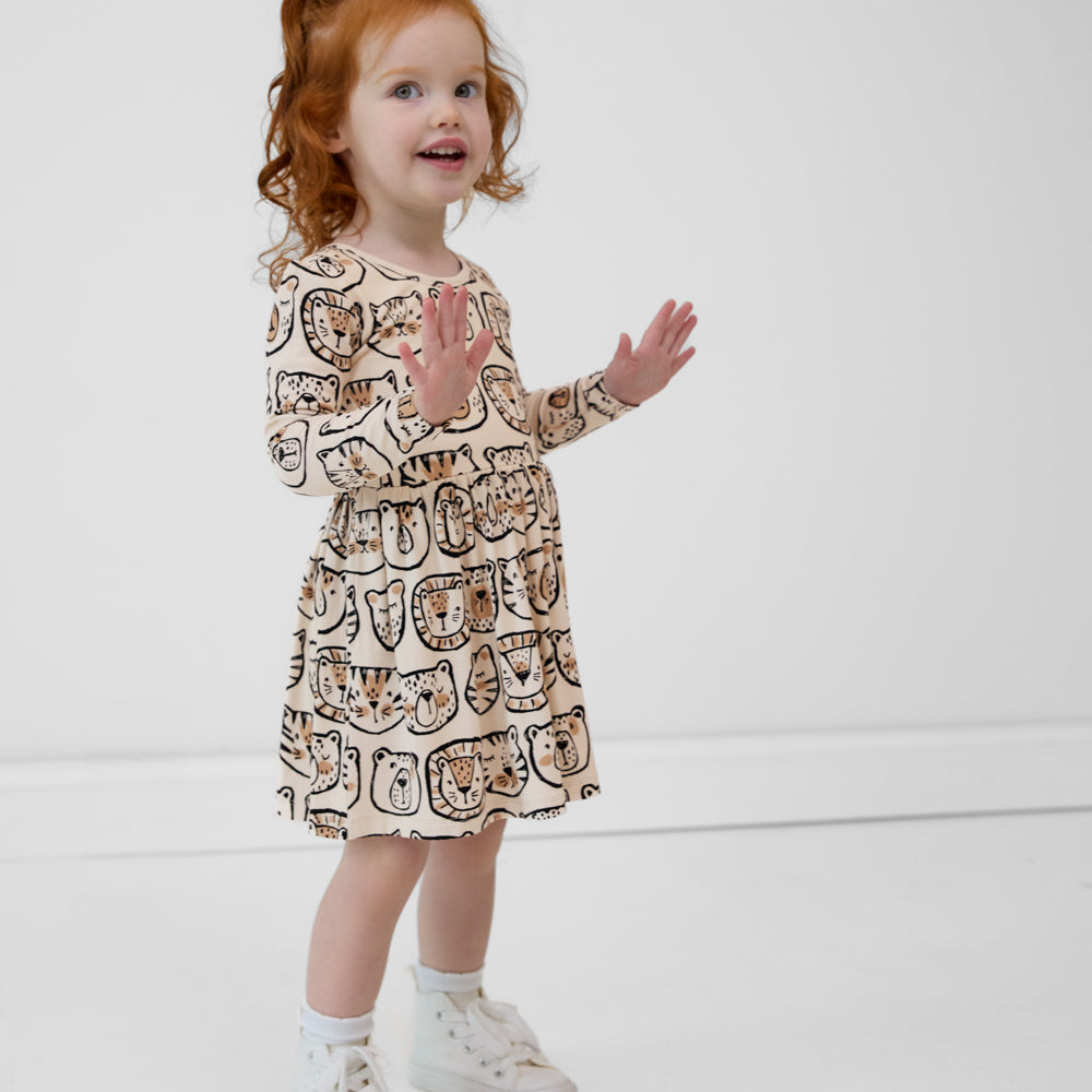 Child with her hands up wearing a Lions, Tigers & Bears long sleeve skater dress