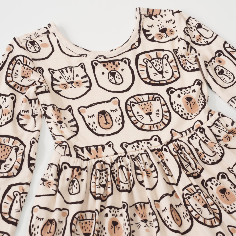 Close-up view of the black and tan animal illustrations on a Lions, Tigers & Bears long sleeve twirl dress