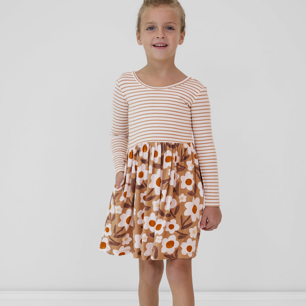 Child with a hand in the pocket of a Daisy Daydream long sleeve twirl dress