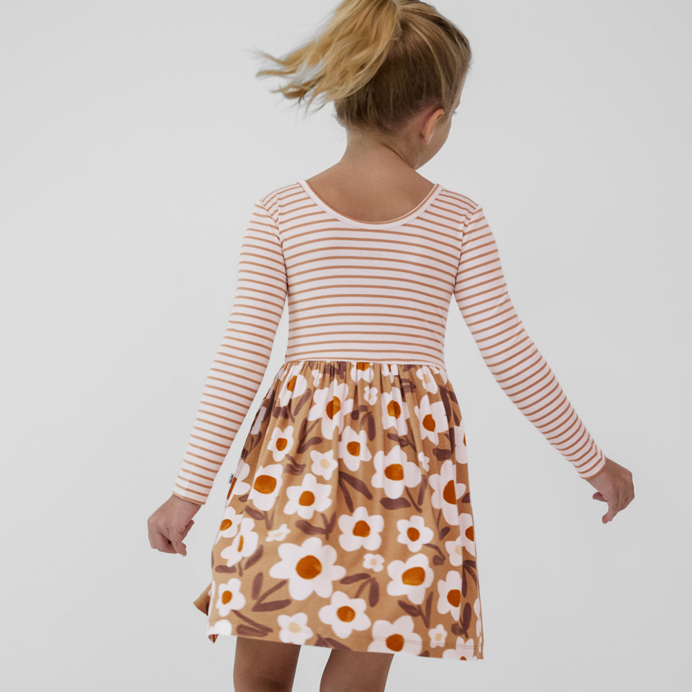 Child spinning around wearing a Daisy Daydream long sleeve twirl dress