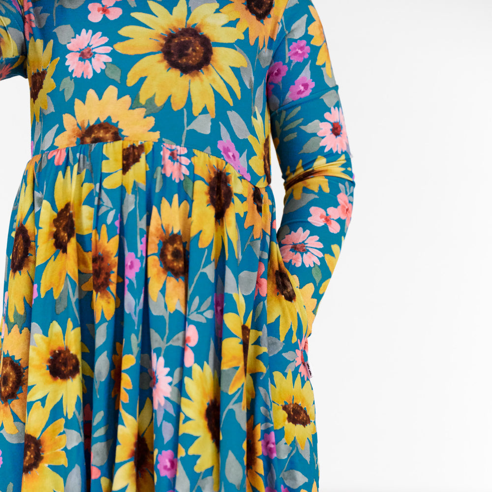 Close up image of a child wearing a Sunflower Fields Twirl Dress, detailing the side pocket