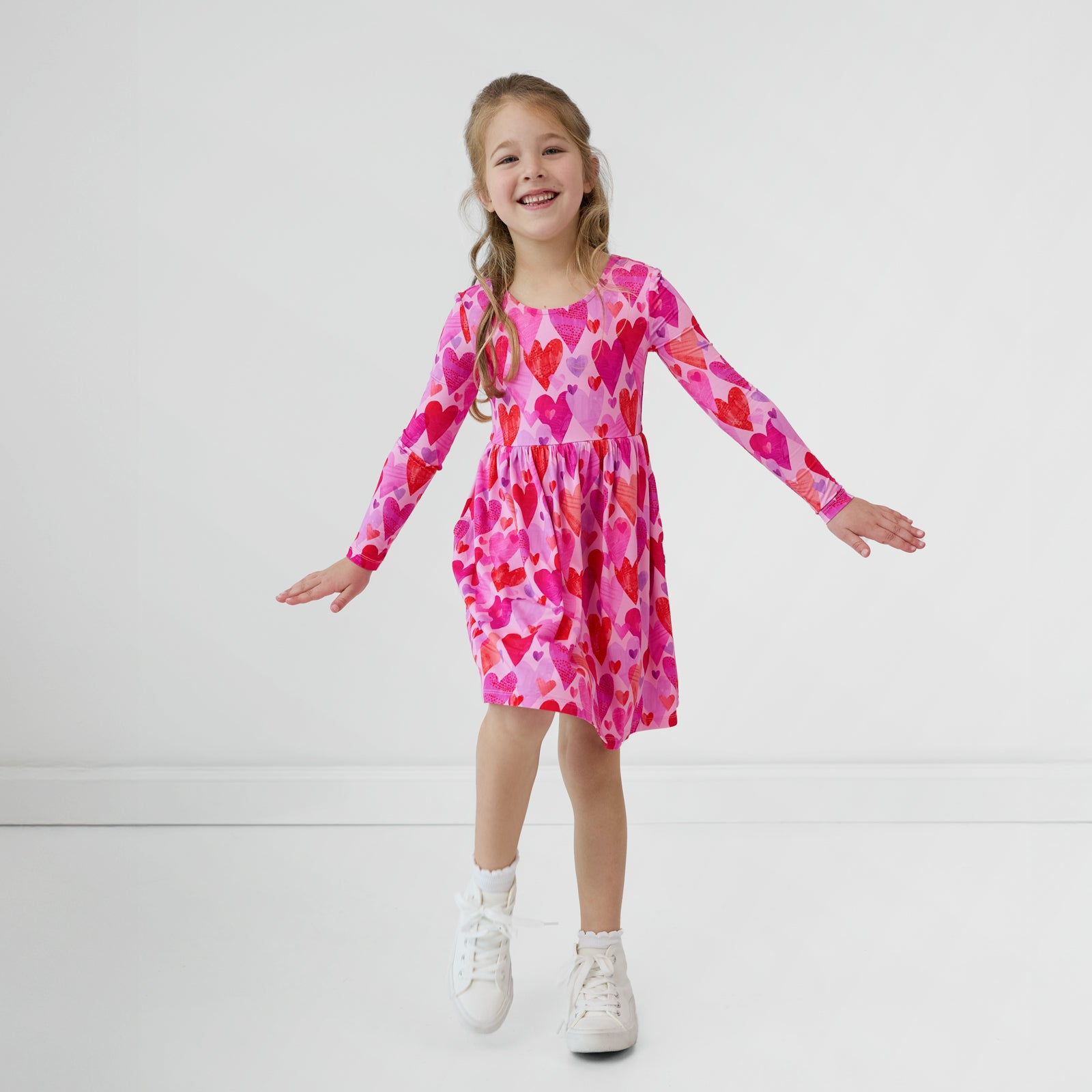 Child with her arms out wearing a Pink Hearts & Crafts Bow Back Skater Dress