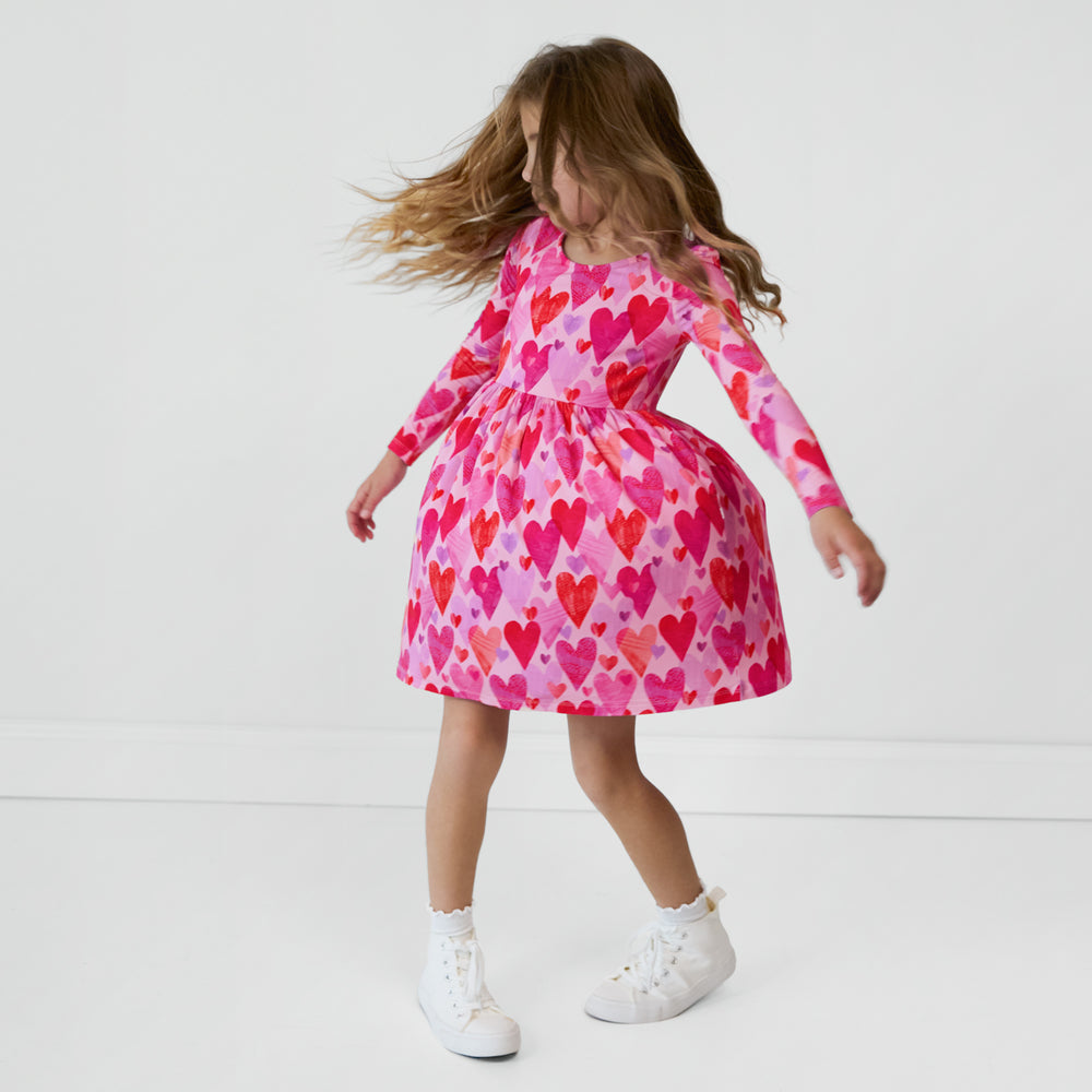 Child spinning around wearing a Pink Hearts & Crafts Bow Back Skater Dress