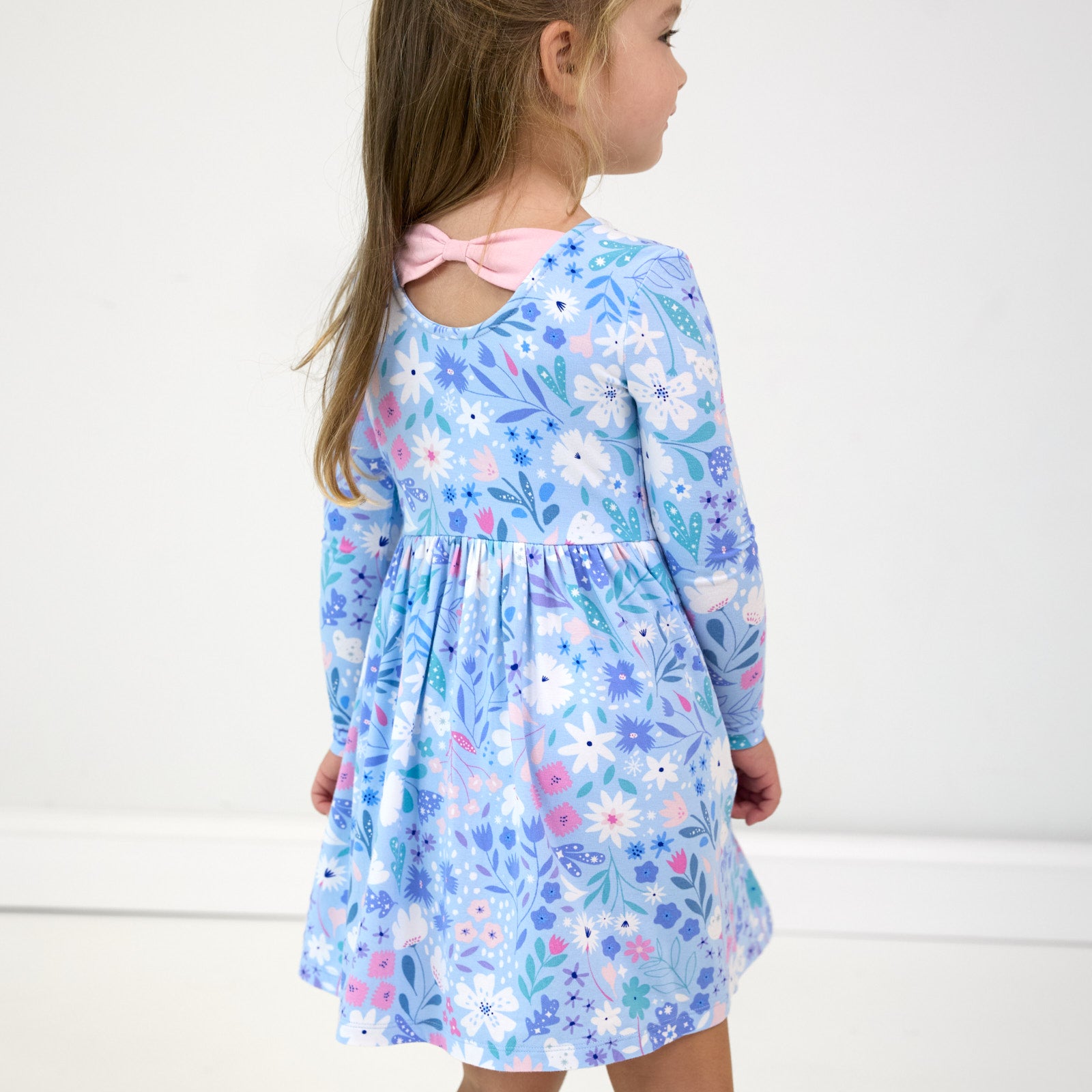 Image of girl showing the back detail on the Magical Meadow Bow Back Skater Dress