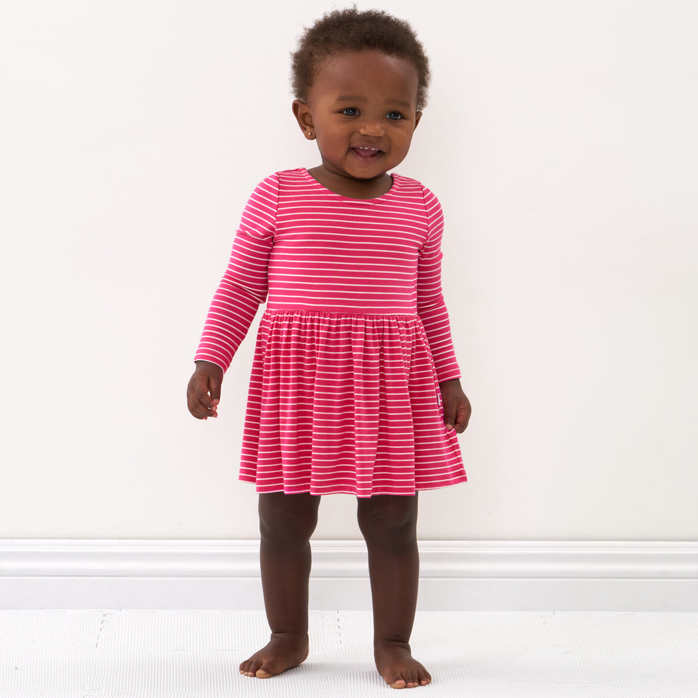 Click to see full screen - Child wearing a Pink Punch Stripes bow back skater dress with bodysuit