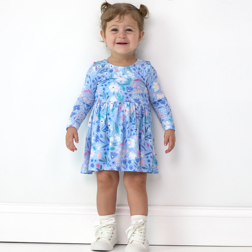 Smiling girl posing while wearing the Magical Meadow Bow Back Skater Dress with Bodysuit