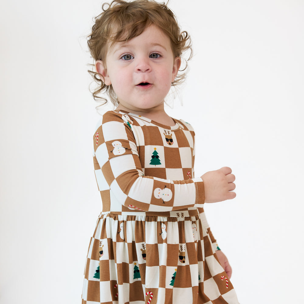 Close up image of a child wearing a Holiday Checks Skater Dress with Bodysuit