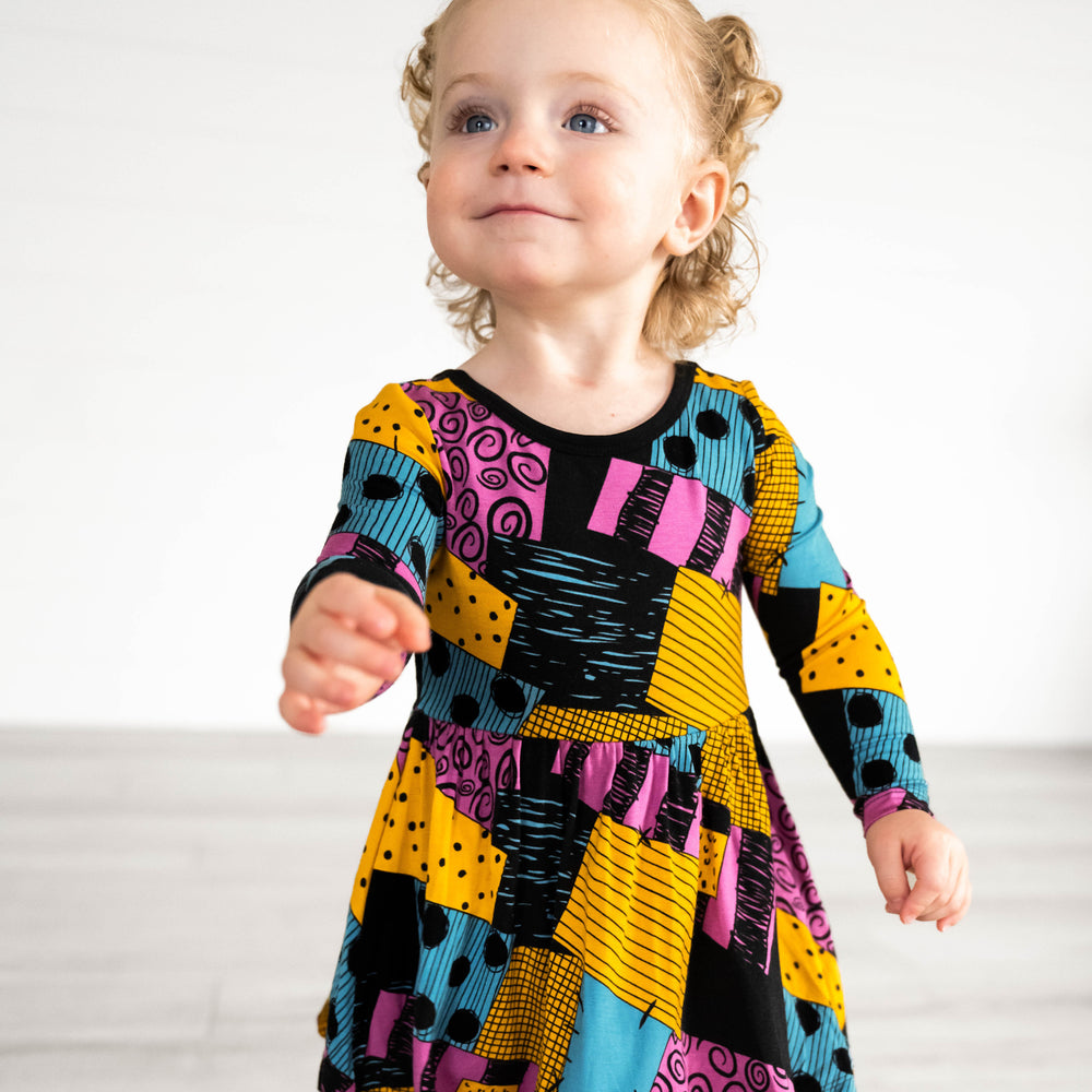 Alternative image of girl posing while in the Disney Sally's Patchwork Twirl Dress with Bodysuit