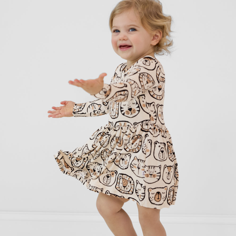 Child spinning around wearing a Lions, Tigers & Bears long sleeve skater dress with bodysuit