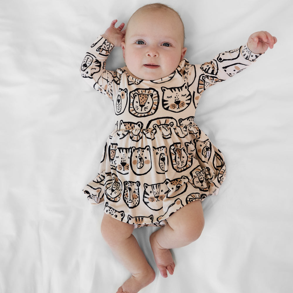 Infant lying down wearing a Lions, Tigers & Bears long sleeve skater dress with bodysuit