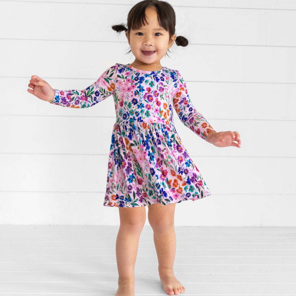 Image of a child wearing a Sweet Pea Floral Twirl Dress with Bodysuit