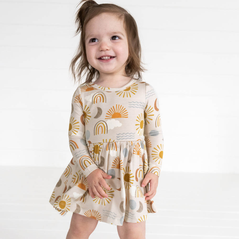 Image of a child wearing a Desert Sunrise Twirl Dress with Bodysuit