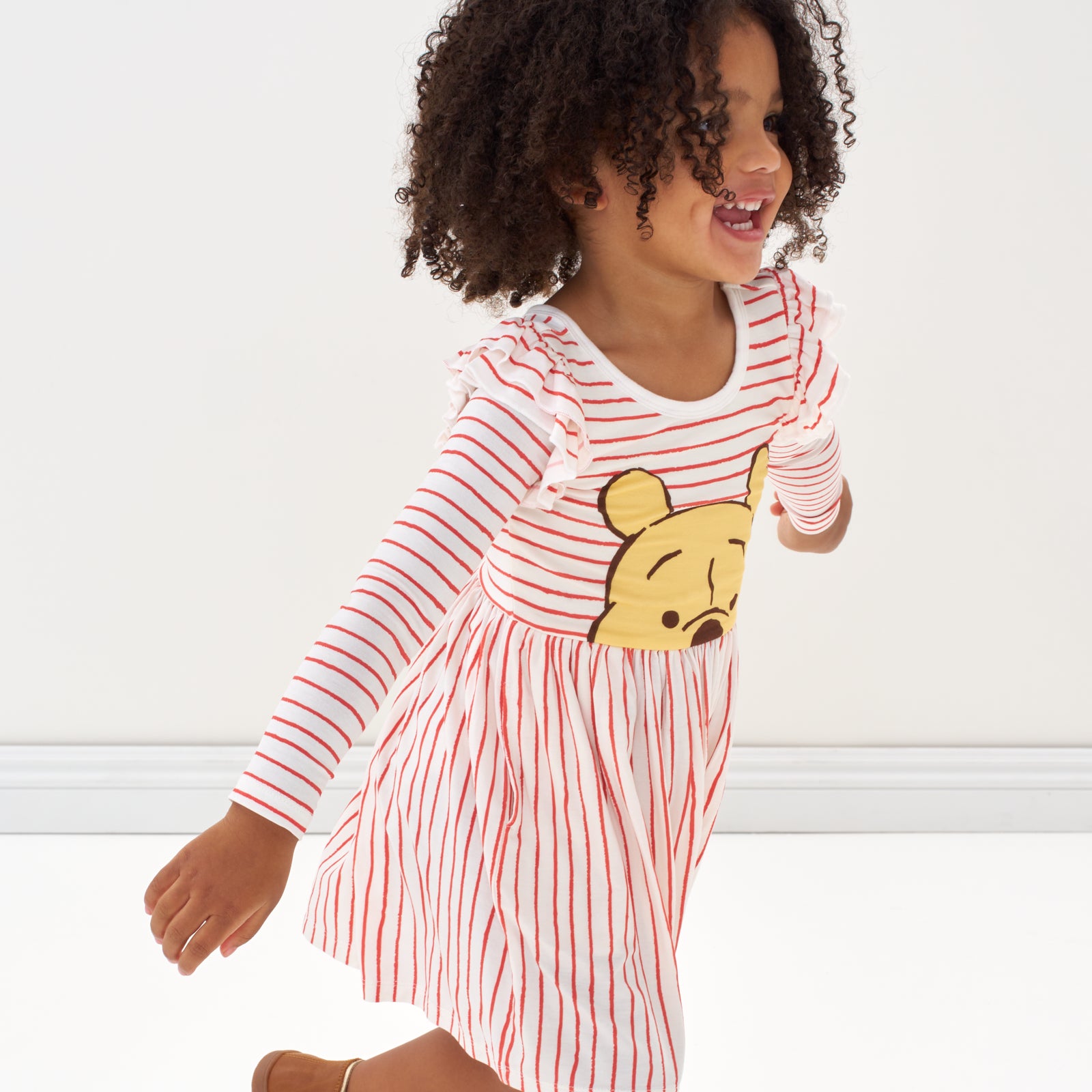 Child running wearing a Disney Winnie the Pooh flutter skater dress