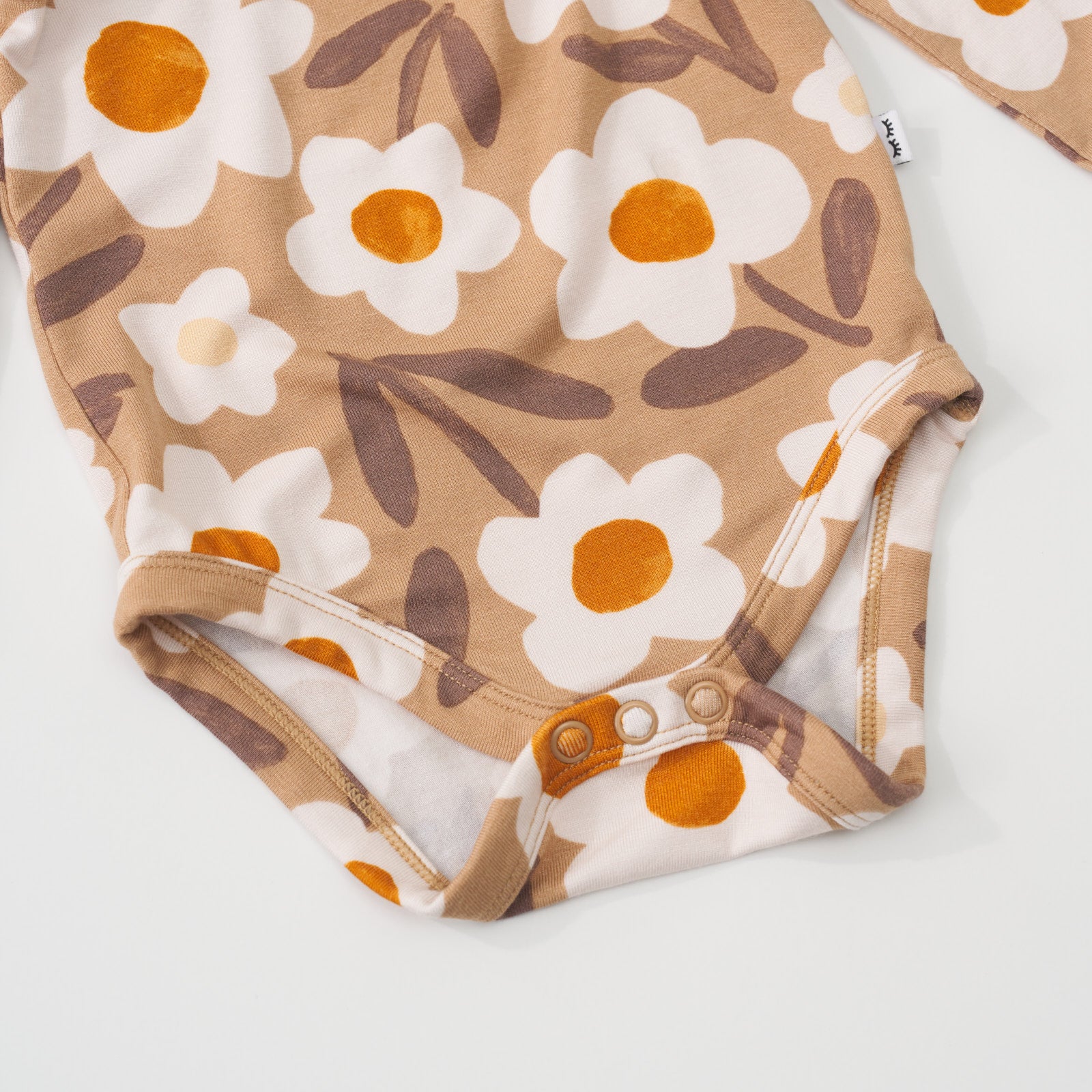 Close-up view of the button snap closure on a Daisy Daydream flutter baby bodysuit