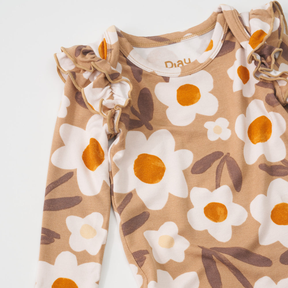 Close-up view of the ruffle shoulders on a Daisy Daydream flutter baby bodysuit