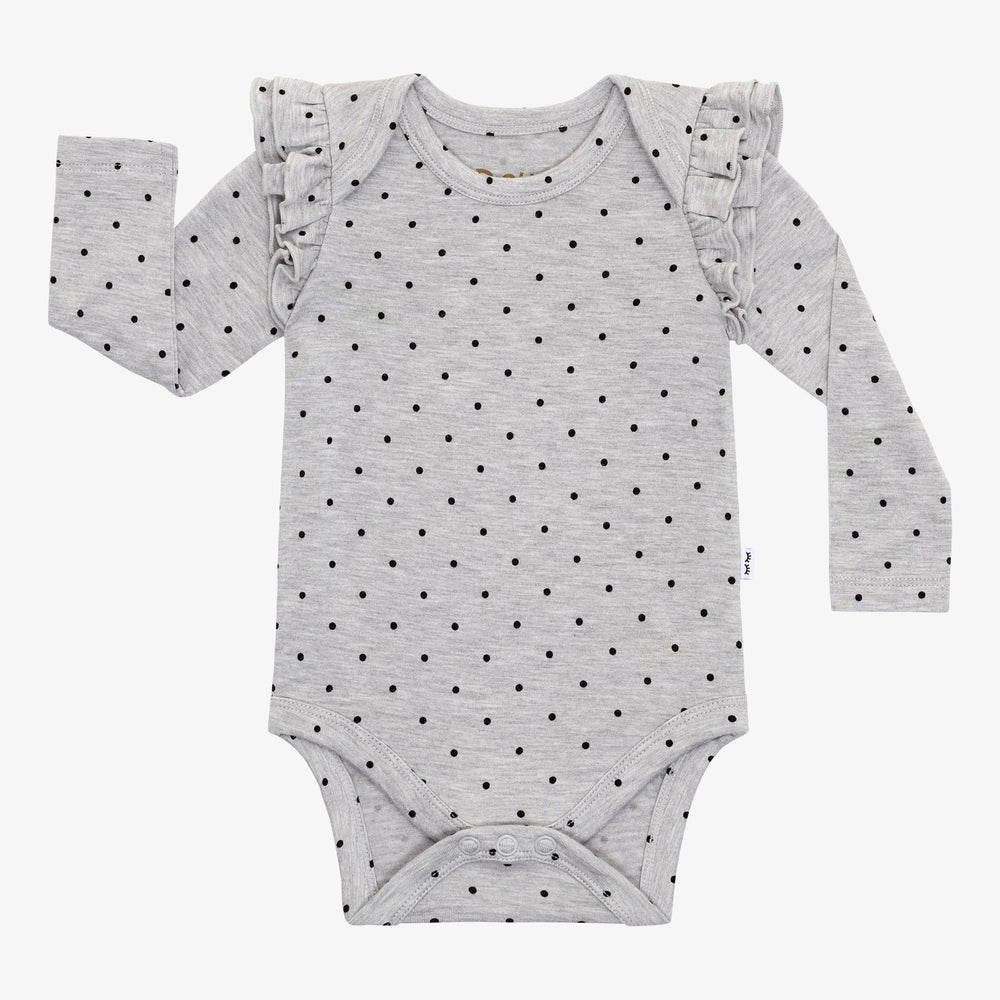 Flat lay of a Ditsy Dots flutter baby bodysuit featuring long sleeves, ruffle shoulders, and black dots on a gray background