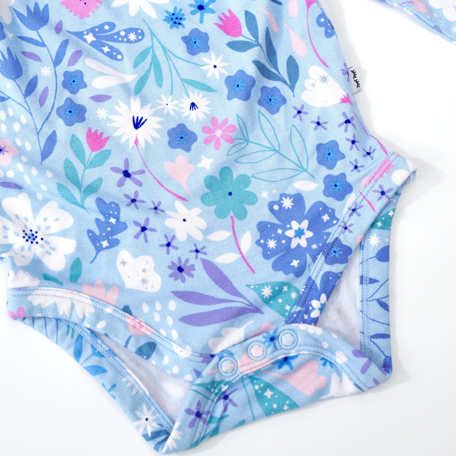 Close up detailed image of the snaps on a Magical Meadow Flutter Bodysuit