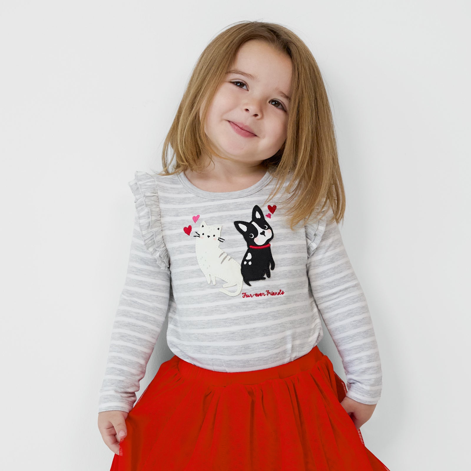 Smiling child wearing a Furever Friends Flutter Tee and coordinating Tutu Skirt