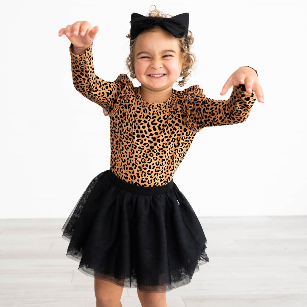 child wearing a Classic leopard play shirt with a black tutu skirt paired with a cat ear luxe bow head