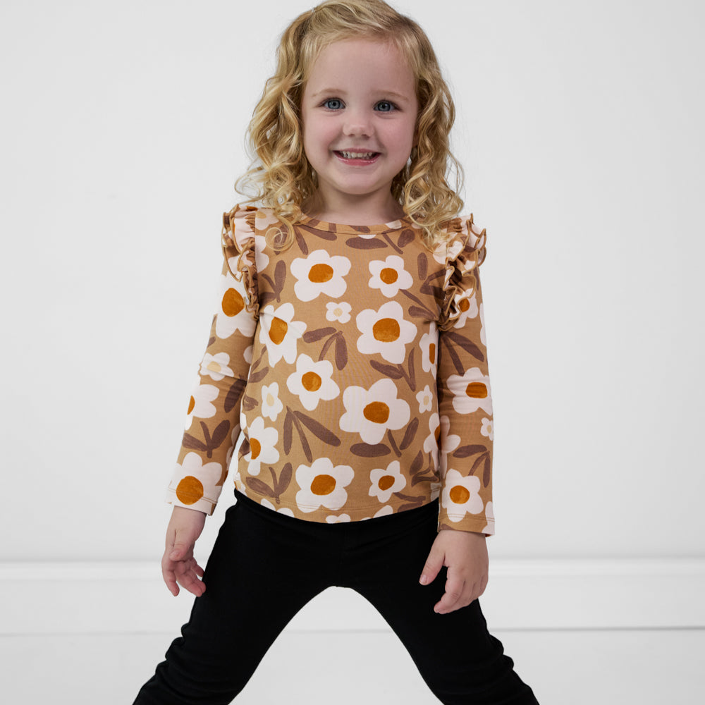 Child wearing a Daisy Daydream flutter tee paired with black leggings