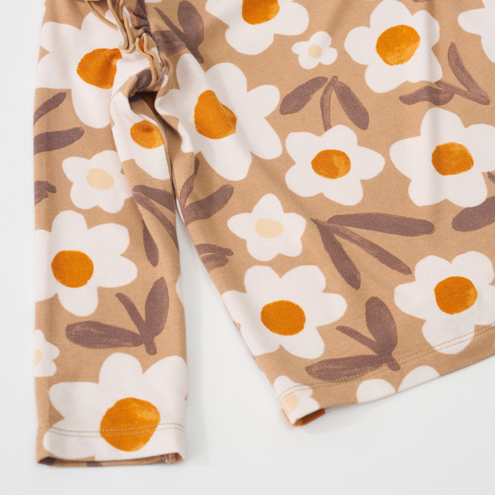 Close-up view of the sleeve hem and bottom hem on a Daisy Daydream flutter tee