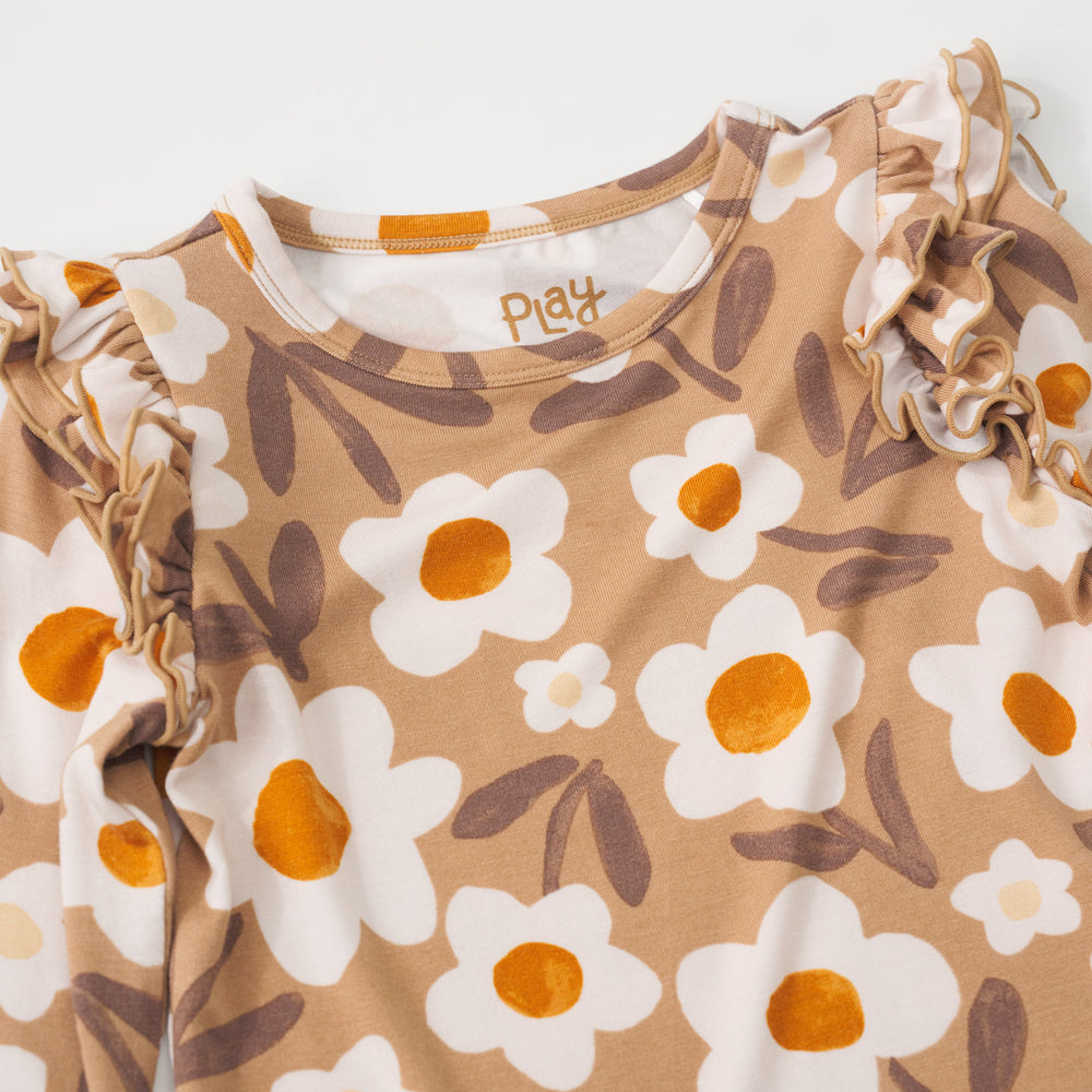 Close-up view of the ruffle shoulders on a Daisy Daydream flutter tee