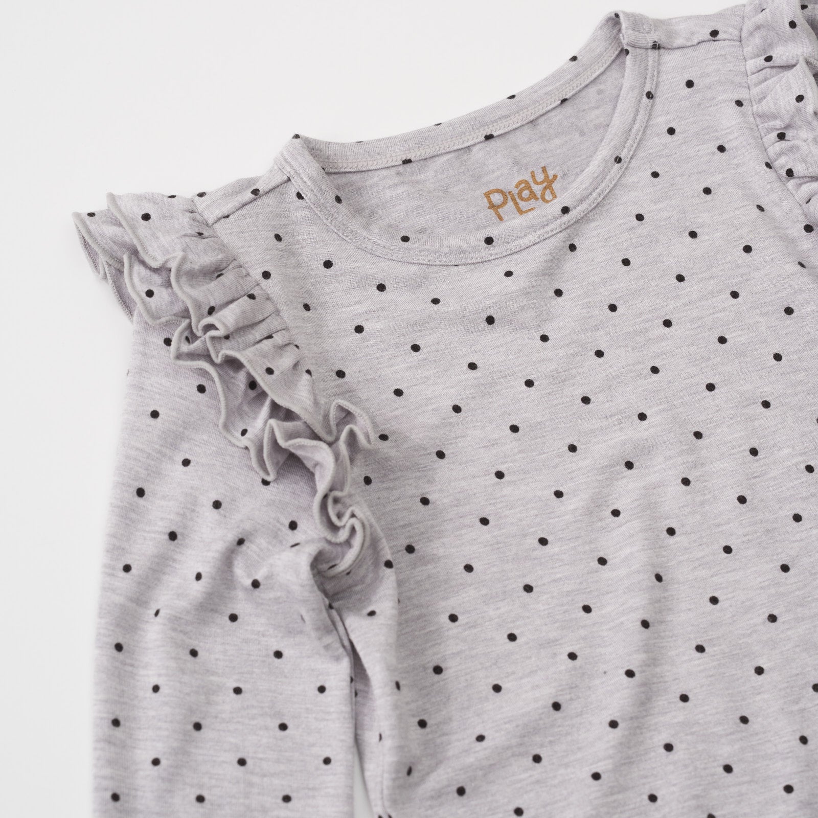 Close-up view of the ruffle shoulder on a Ditsy Dots long sleeve flutter tee