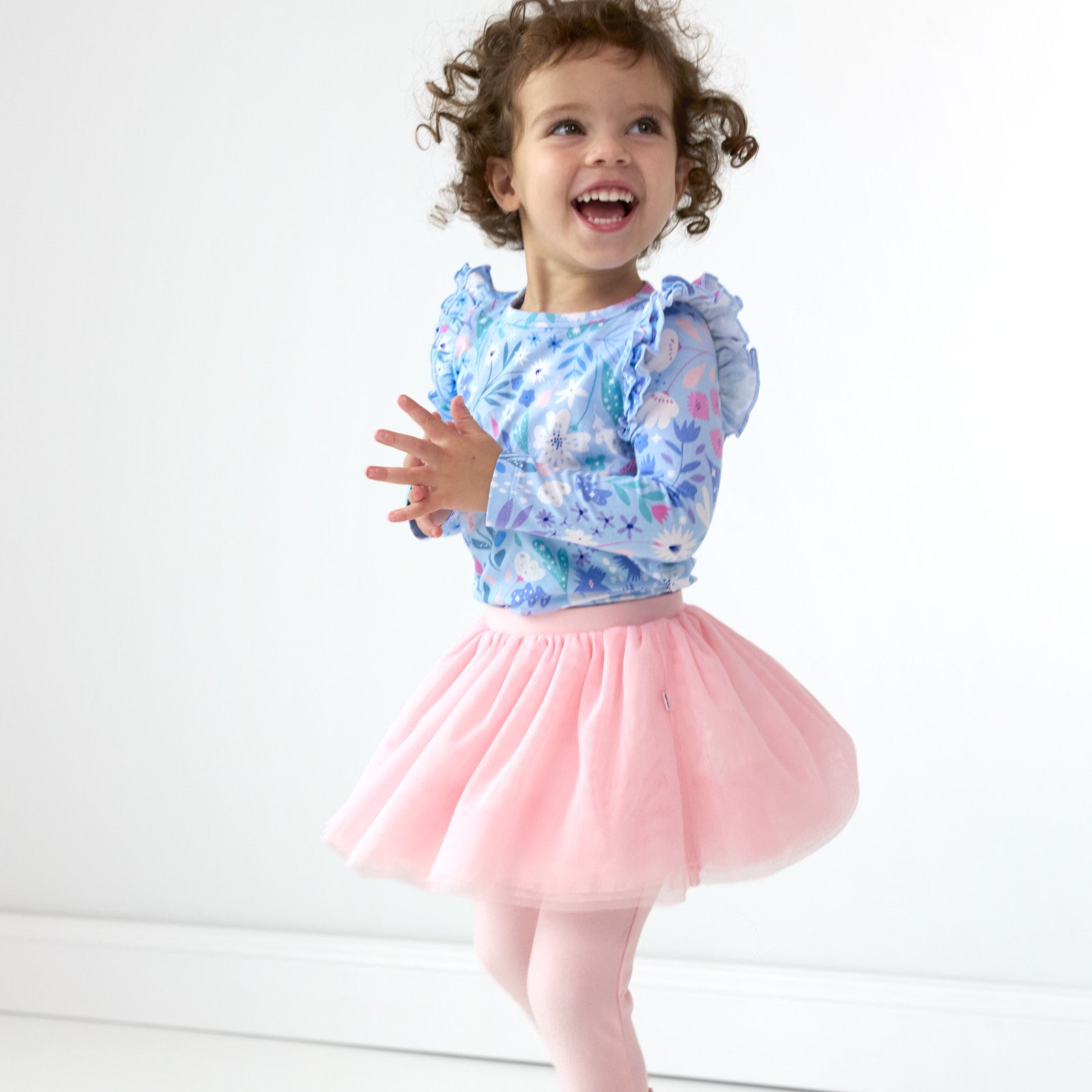 Smiling girl and posing while wearing the Prima Pink Tutu Legging and Magical Meadows Flutter Tee