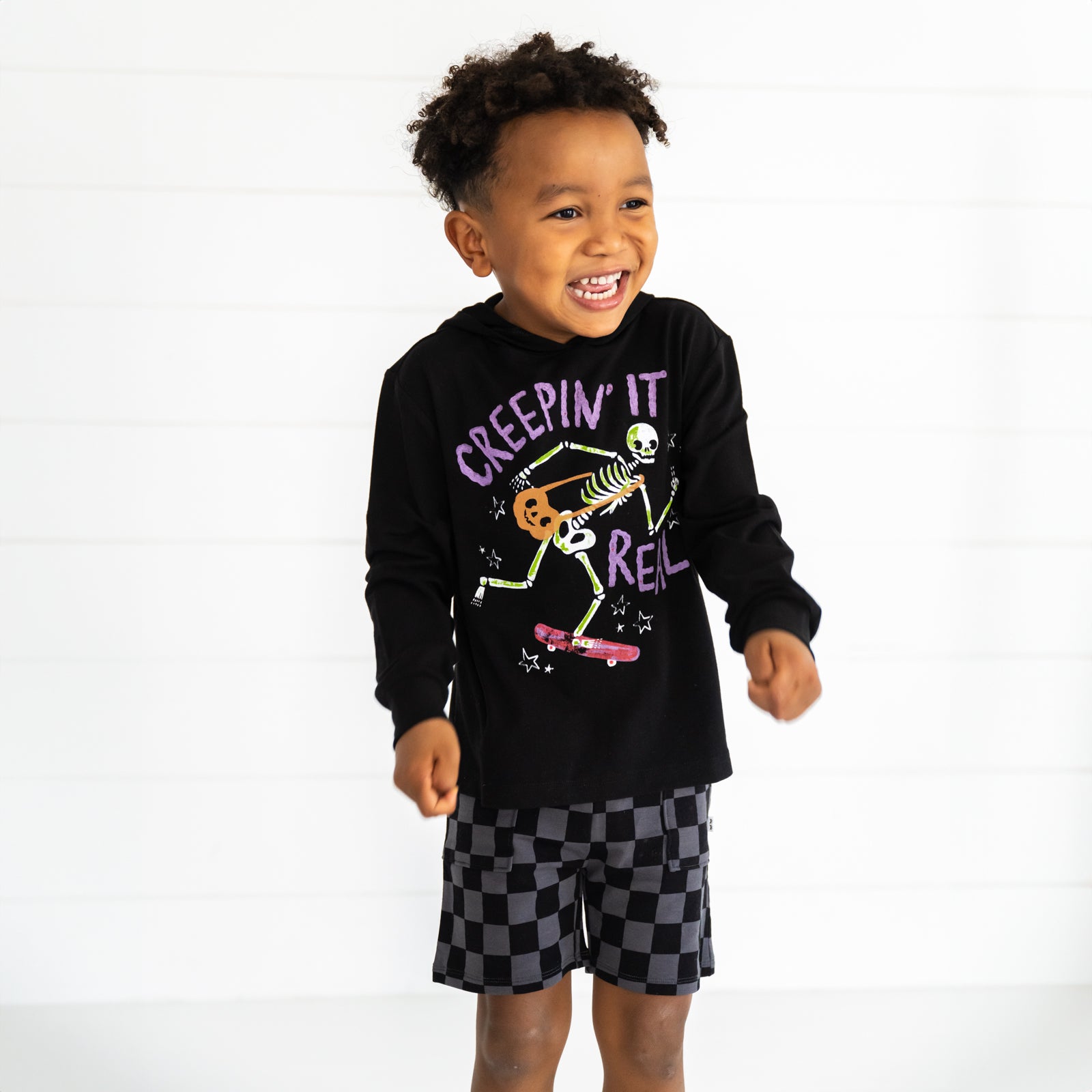 Child wearing a Creepin' It Real Hooded Tee and Monochrome Checks Shorts