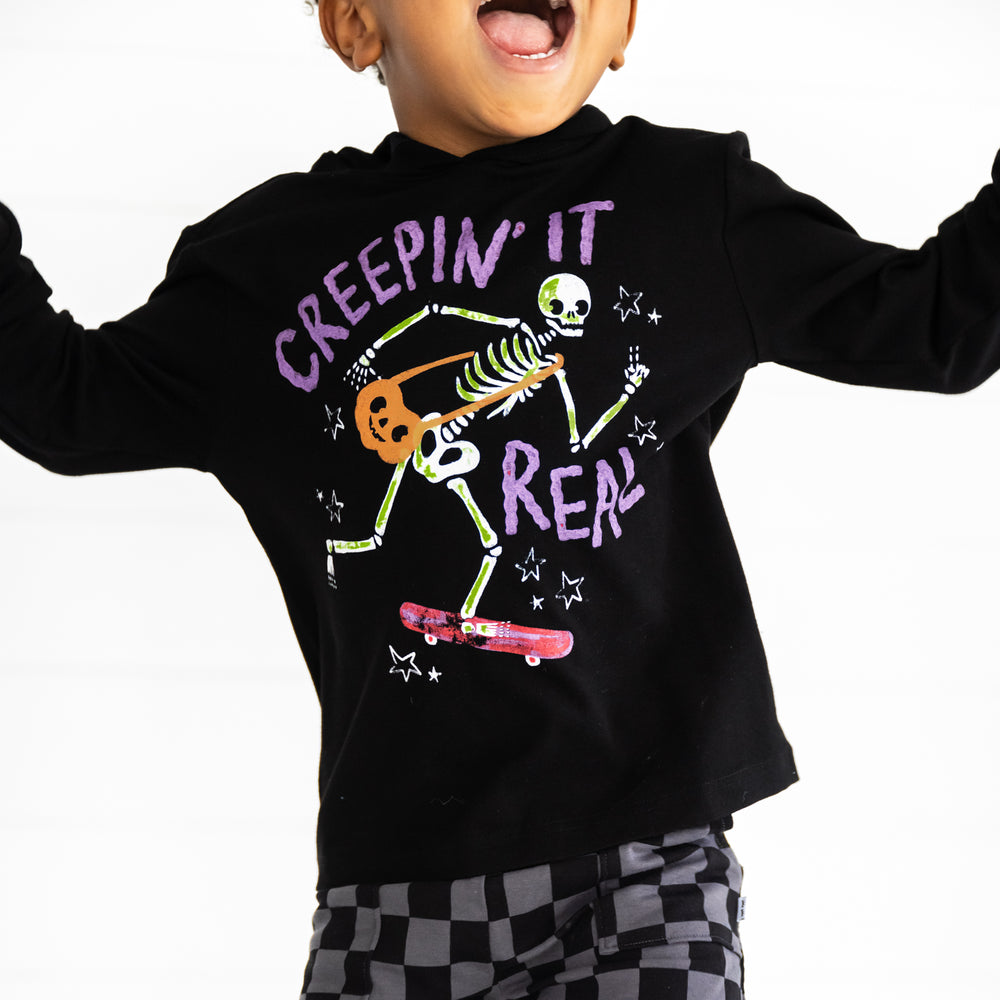 Close up image of a child wearing a Creepin' It Real Hooded Tee and Monochrome Checks Shorts