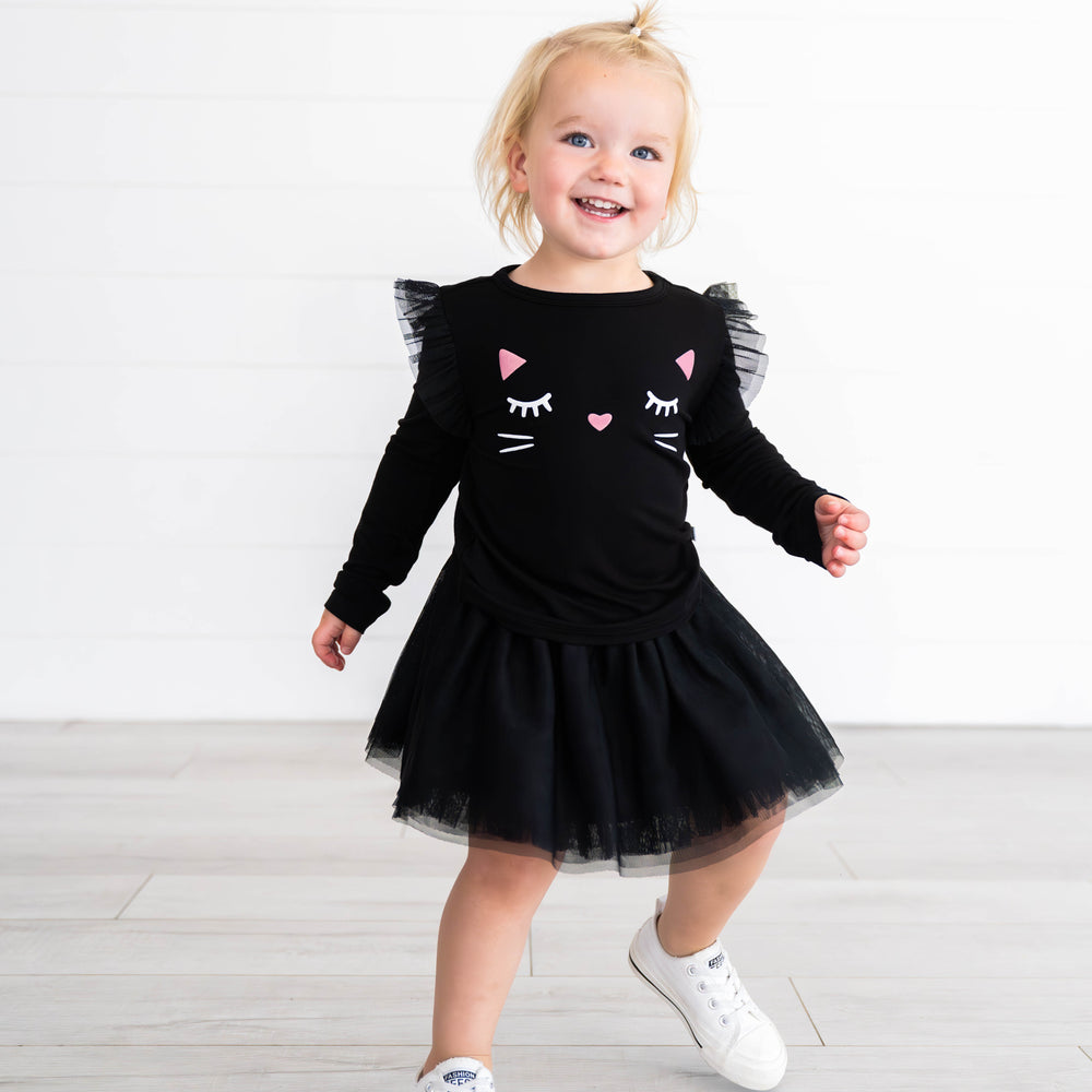 Girl posing while wearing the Black Cat Graphic Flutter Tee & Black Tutu Skirt