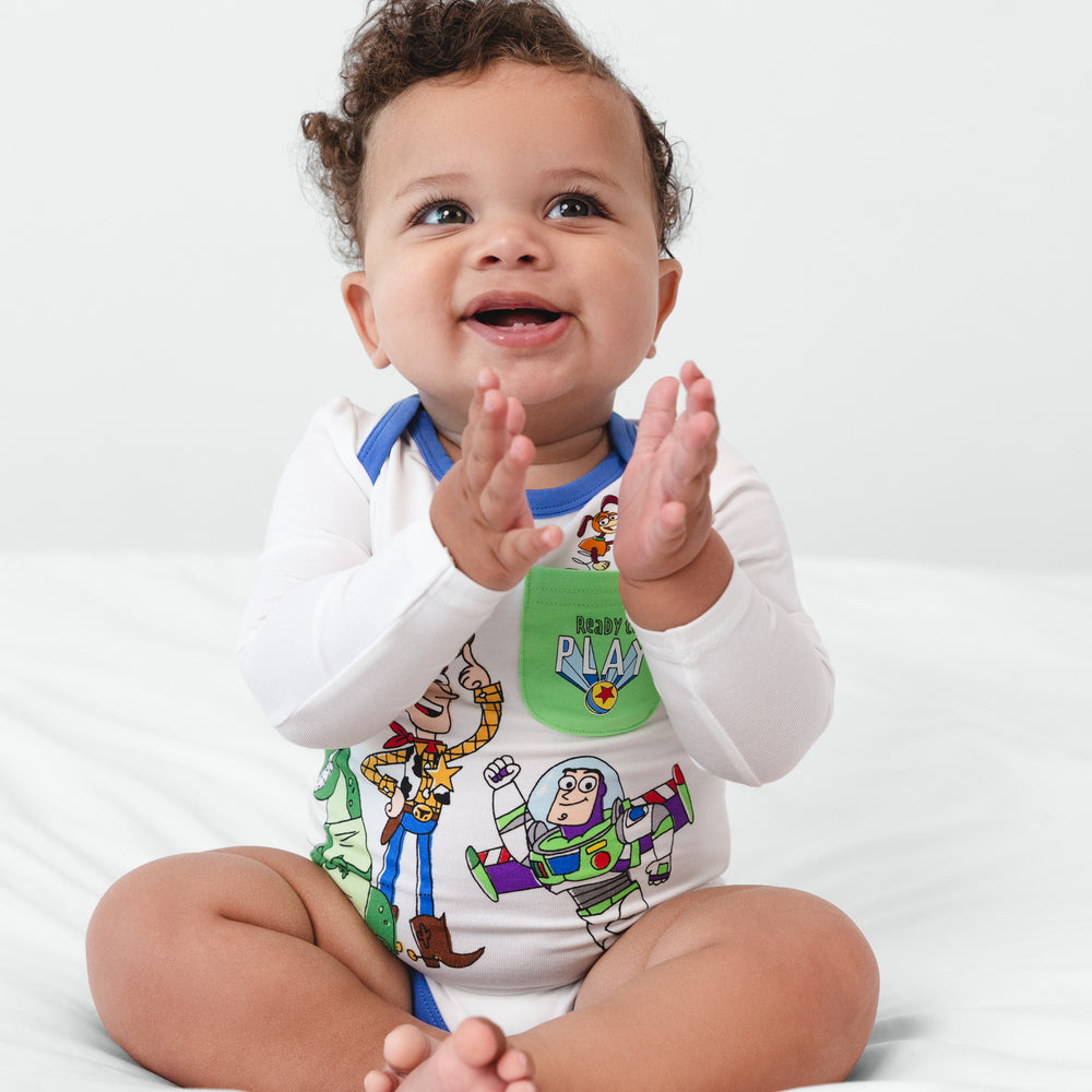 Infant sitting on a blanket clapping their hands wearing a Disney & Pixar Toy Story Pals Bodysuit