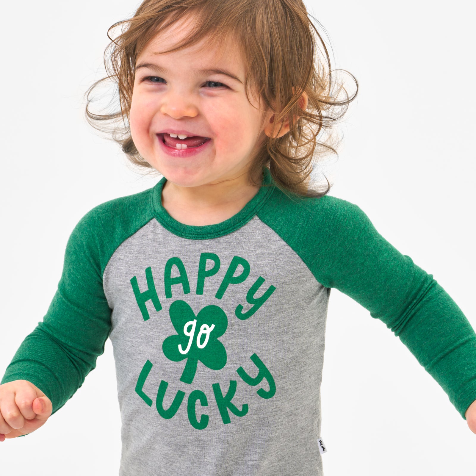 Close up image of a child wearing a Happy Go Lucky graphic bodysuit