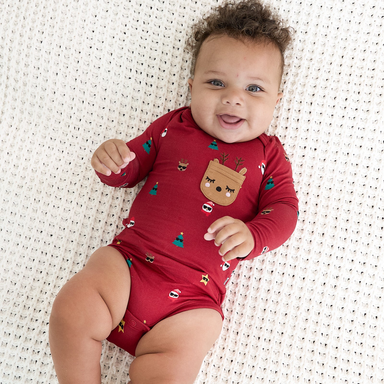 Image of an infant laying on a blanket wearing a Cool Christmas Bodysuit