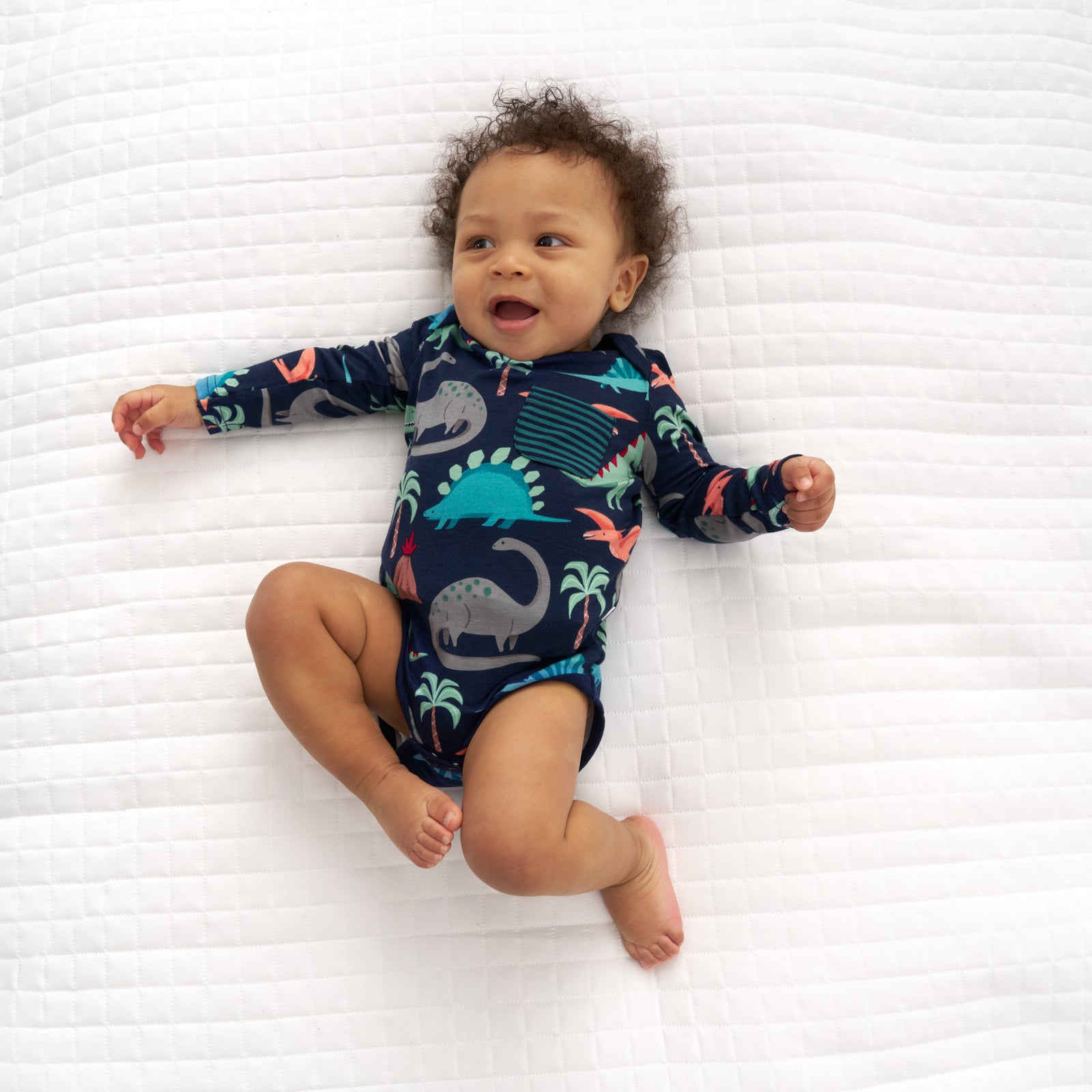 Alternate image of a child laying on a blanket wearing a Blue Prehistoric Pals pocket bodysuit