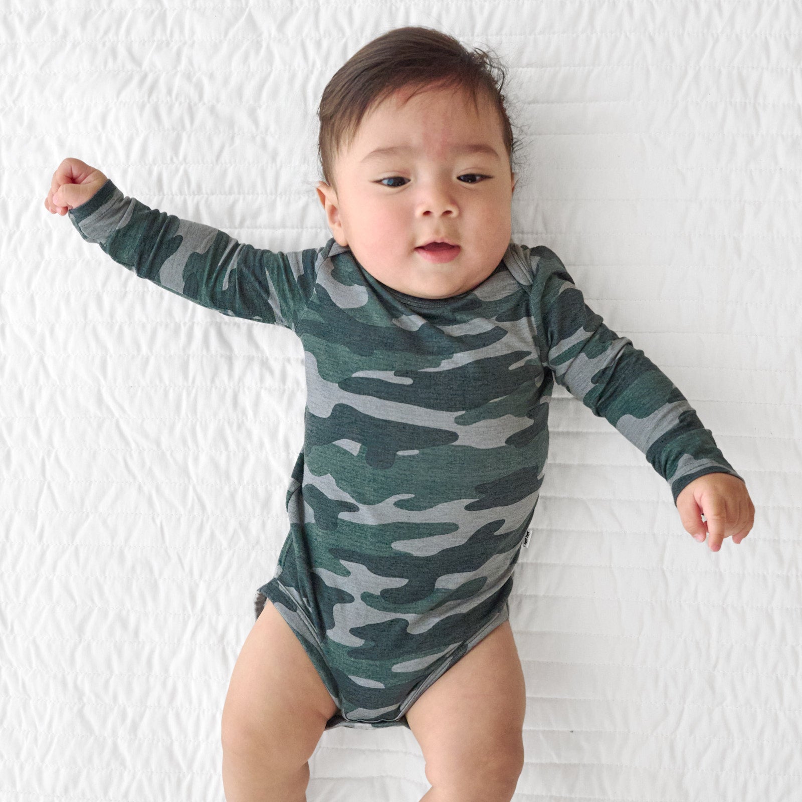 Top view image of baby laying down while in the Vintage Camo Long Sleeve Bodysuit